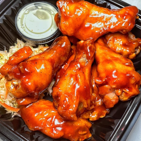 Vauxhall's buffalo wings, coated in bright orange sauce, with a side of coleslaw and ranch dressing.