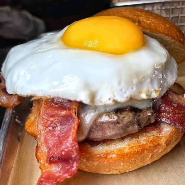 A Vauxhall burger with a fried egg, bacon, and melted cheese on a toasted bun.